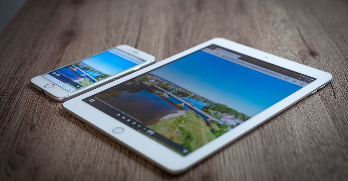 iPad and iPhone showing a scenic landscape on a wooden table, highlighting portability and technology.